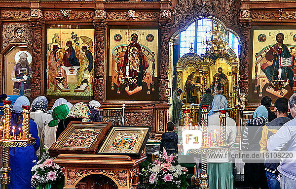 Astrakhan  Russia. The Dormition Cathedral is located in the Kremlin of Astrakhan. The crowd of believers gathers in front of the iconostasis covered with icons. The iconostasis is considered as a door to the divine world.