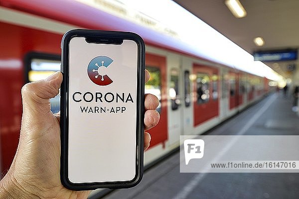 Hand hält Smartphone mit Corona Warn-APP am Bahnsteig  Corona-Krise  Stuttgart  Baden-Württemberg  Deutschland  Europa
