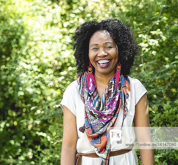 Porträt einer lachenden  dunkelhäutigen Frau mit lockigen Haaren und buntem Schal  Deutschland  Europa
