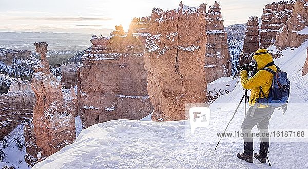 Tourist taking pictures  rock formation Thors Hammer  morning light  sunrise  bizarre snowy rock landscape with hoodoos in winter  Navajo Loop Trail  Bryce Canyon National Park  Utah  USA  North America