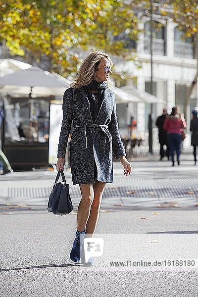 54 year old blonde woman with a handbag crossing the street in the Retiro district  Madrid