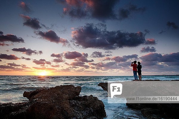 Frauen fotografieren den Sonnenuntergang am Meer  Sardinien Italien