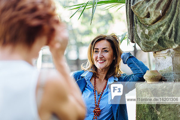 Zwei Frauen  im Freien  einander zugewandt  lächelnd