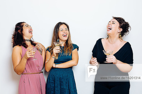 Freunde lachen und feiern mit Getränken