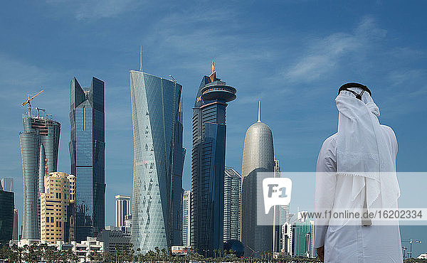 Mann mit Blick auf futuristische Wolkenkratzer in der Innenstadt von Doha  Katar