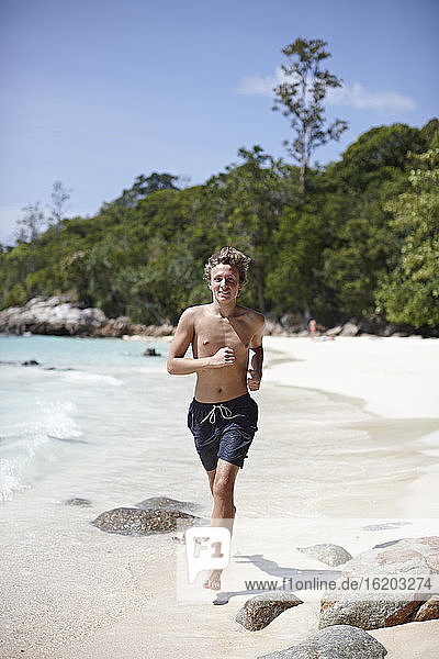 Young man running along beach  Koh Lipe  Thailand