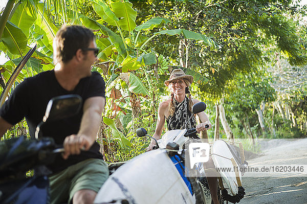 Pärchen auf Motorrädern mit Surfbrettern  Nusa Lembongan  Indonesien