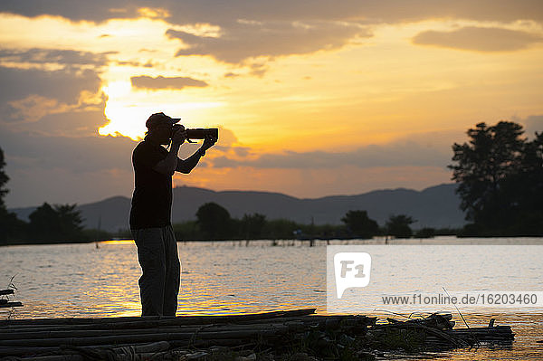 Photographer taking photograph at sunset  Mandalay  Burma