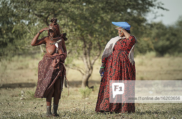 Zwei Himba-Frauen  die ihre Augen vor der Sonne schützen  Namibia  Afrika