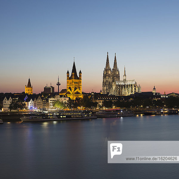 Stadtbild am Wasser mit Rathaus  Großer Martinskirche und Kölner Dom in der Abenddämmerung  Köln  Deutschland