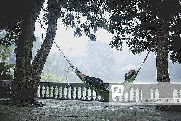 Mann entspannt sich in einer Hängematte  Vietnam