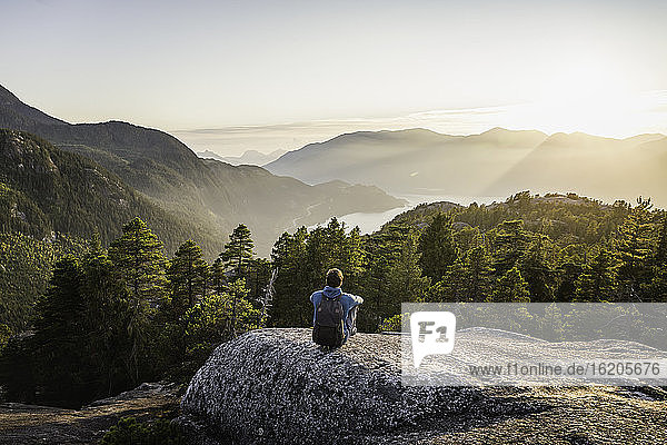 Man sitting on rock  looking at view  Stawamus Chief  overlooking Howe Sound Bay  Squamish  British Columbia  Canada