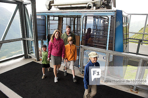 Familie mit drei Kindern beim Aussteigen aus der Straßenbahn im Alyeska Resort  Girdwood  Alaska  USA