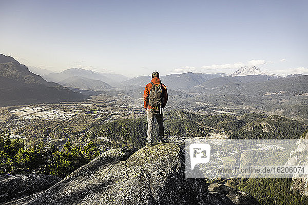 Mann steht auf einem Berg und betrachtet die Aussicht  Stawamus Chief  mit Blick auf die Howe Sound Bay  Squamish  British Columbia  Kanada