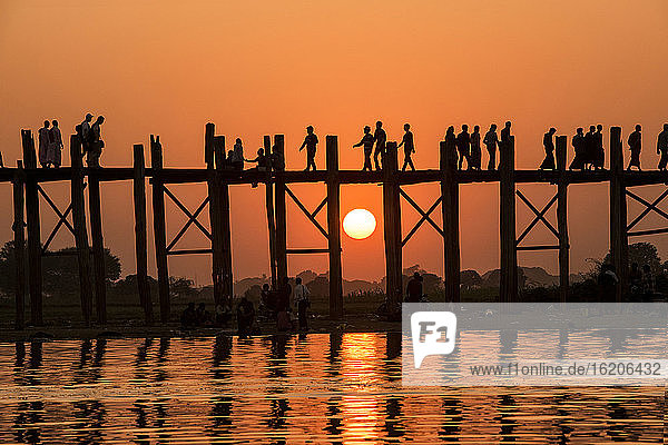 Spaziergänger auf der Bein-Brücke bei Sonnenuntergang  Amarapura  Mandalay  Myanmar
