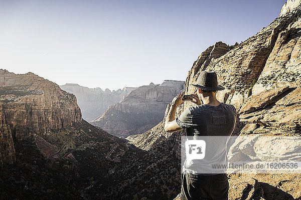 Mann stehend auf Berg  fotografierend  Blick Zion National Park  Utah  USA