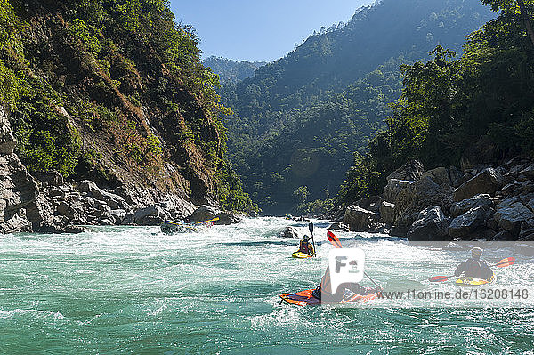 Kayakers negotiate their way through whitewater rapids on the Karnali River in west Nepal  Asia
