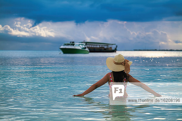 Eine Touristin in den blauen Gewässern der Malediven  Indischer Ozean  Asien