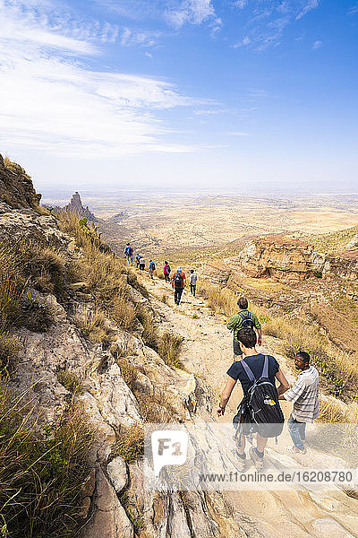 Hikers venture on rock path towards the rock-hewn churches of Gheralta Mountains  Tigray Region  Ethiopia  Africa