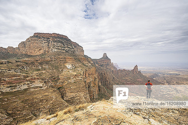 Male hiker admiring Gheralta Mountains canyons from top of rocks  Tigray Region  Ethiopia  Africa