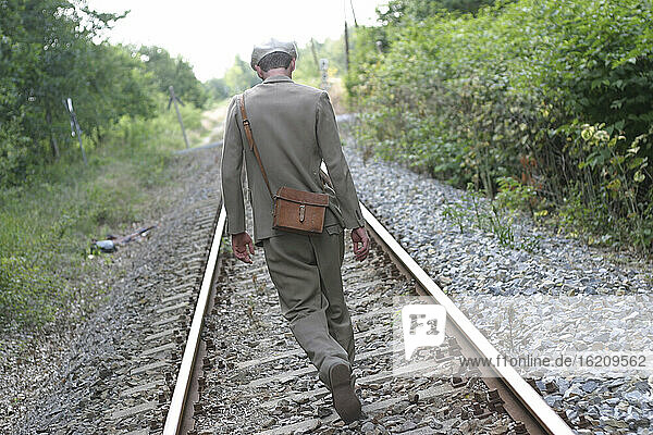 man with shoulderbag on the railroad