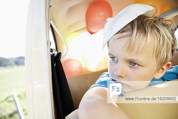 Deutschland  Nordrhein-Westfalen  Köln  Junge im Auto mit Osterhasenmaske  schaut weg