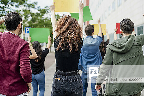 Multiethnische Aktivisten halten Transparente  während sie auf einer Straße in der Stadt protestieren