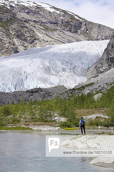 Norwegen  Nigardsbreen  Gletscherzunge  Wanderer am Ufer  Rückansicht