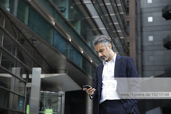 Geschäftsmann benutzt Smartphone in der Stadt
