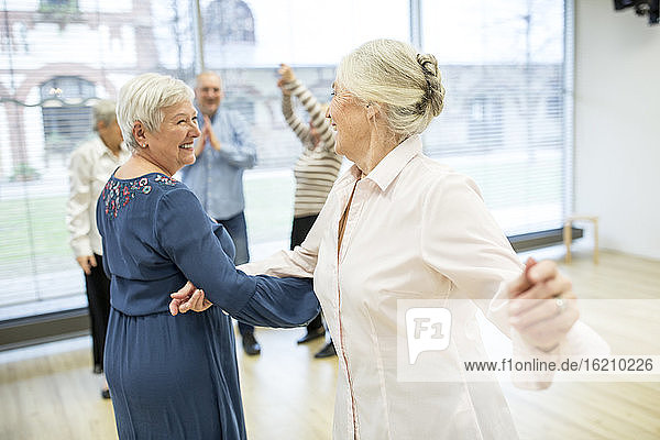 Group of active senior attending dance course in retirement home