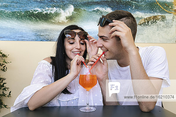 Happy young couple sharing an aperitif
