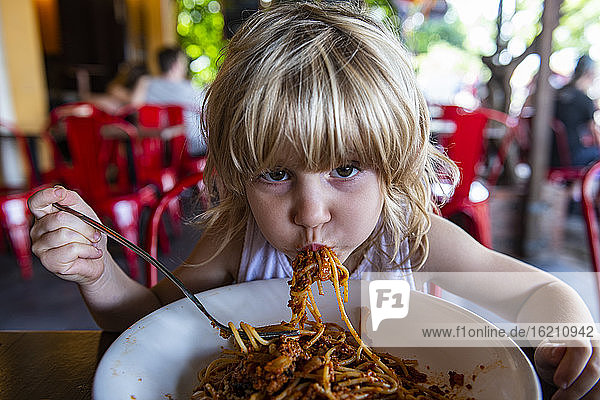 Mädchen isst Spaghetti im Restaurant
