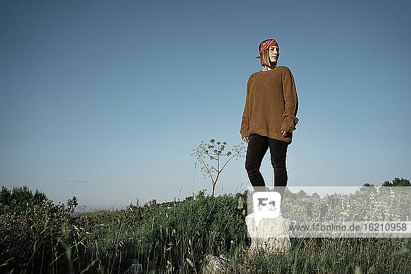Frau auf dem Lande auf einem Felsen stehend