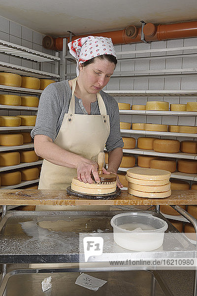 Deutschland  Baden Württemberg  Mittlere erwachsene Frau bestreut Käse mit Salzwasser