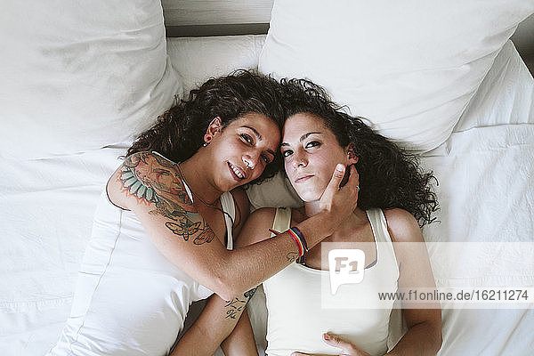 Junges lesbisches Paar entspannt sich auf dem Bett zu Hause