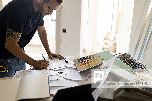 Man working on construction plan and colour swatch
