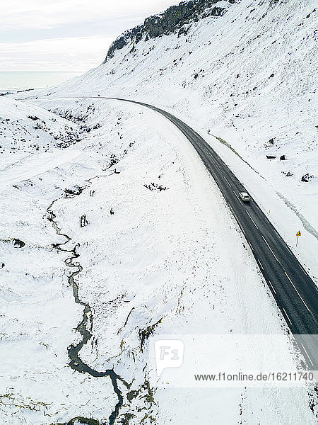 Asphaltstraße in schneebedeckten Bergen