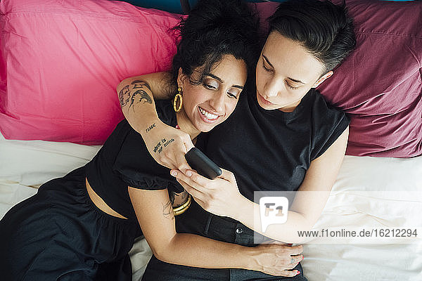 Lesbisches Paar textet im Schlafzimmer