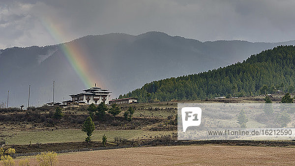 Bhutan  Blick auf den Dhomkhar-Palast mit Regenbogen