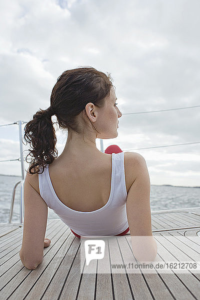 Germany  Baltic Sea  Lübecker Bucht  Woman sitting on yacht  rear view