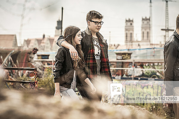 Cooles Teenager-Paar  das in einem alten  heruntergekommenen Industriegebiet spazieren geht