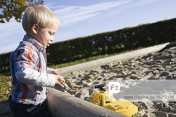 Kleiner Junge (2-3) spielt im Sandkasten