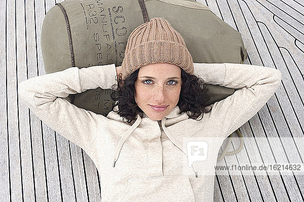 Germany  Baltic Sea  Lübecker Bucht  Portrait of a young woman lying on deck of yacht  smiling