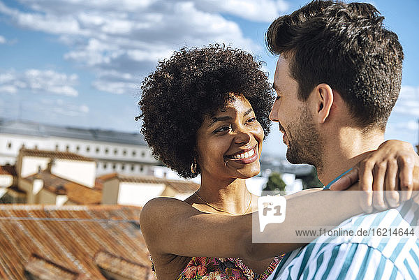 Romantische Mitte erwachsenen Paar umarmt gegen Himmel während sonnigen Tag