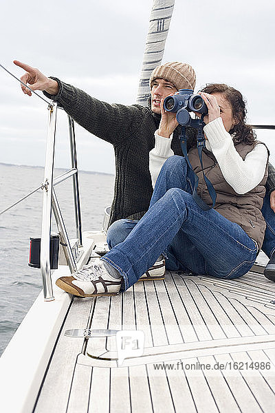 Germany  Baltic Sea  Lübecker Bucht  Young couple on boat  woman looking through binoculars