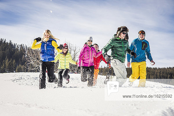 Gruppe unbeschwerter Freunde beim Laufen und Spaß haben im Schnee  Achenkirch  Österreich