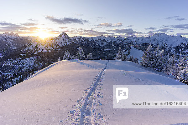 Skispuren auf dem schneebedeckten Gipfel des Schonkahler Berges bei Sonnenaufgang