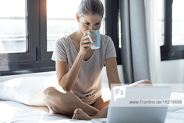 Blond woman using laptop at home