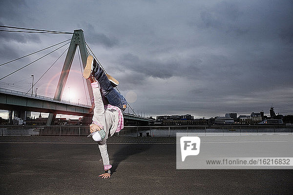 Deutschland  Köln  Junger Mann beim Breakdance  Rheinbrücke im Hintergrund