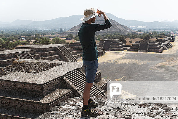 Mature man wearing hat standing on pyramid against sky in Teotihuacan  Mexico